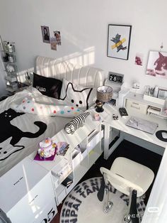 a bedroom with white furniture and black and white decor on the walls, including a bed