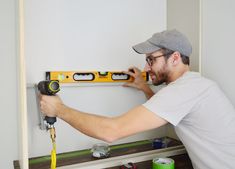 a man is measuring the wall with a spirit level