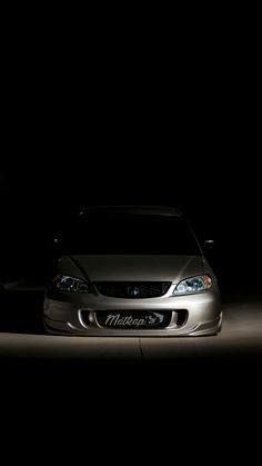 a car parked in the dark with its headlights on