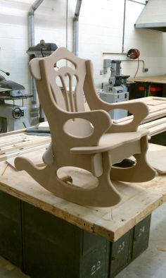 a wooden chair sitting on top of a table in a room filled with machines and tools