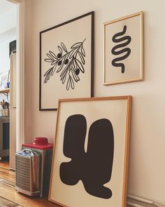 two framed pictures hang on the wall above a wooden floor