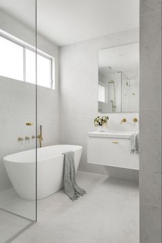 a white bathtub sitting next to a sink in a bathroom