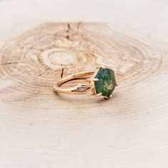 a green ring sitting on top of a piece of wood