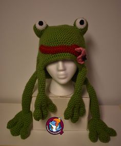 a crocheted frog hat on top of a mannequin head