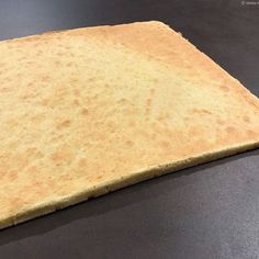 a piece of bread that is on top of a table with a black surface in front of it