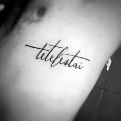 a woman's upper arm with the word tattoo on her left side ribcage