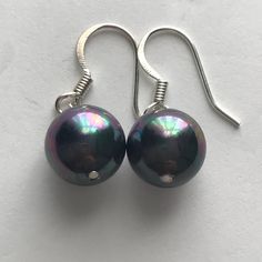 10mm or 12 mm Black Tahitian Shell Pearl Earrings with stunning overtones of green, blue, purple and silver. Silver lever back, fishhook  ear wire or Stud Wire.   Dainty Dangle Earrings, Drop Earrings, Mother'S Day Birthday Christmas Gift for Women Girls, Bridal Shower Gift, Wedding Jewelry, Large Pearl Earring  Elegant Earrings Shell Pearls are made from the inner lining of oyster shells, also known as Mother of Pearl. The substance is ground to a fine powder, shaped, dyed and coated with natural pearl nacre and then a protective coating to give it lustre  to resemble Tahitian, South Sea, or freshwater cultured pearls. They are an affordable alternative to their more expensive counterparts. Dainty Dangle Earrings, Large Pearl Earrings, Christmas Gift For Women, Pearls Earrings, Purple And Silver, Jewelry Elegant, Oyster Shells, Pearl Earring, Wedding Jewelry Earrings