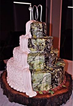 a three tiered wedding cake on top of a tree stump with mossy decorations