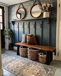 a bench with two mirrors above it and some baskets on the floor next to it