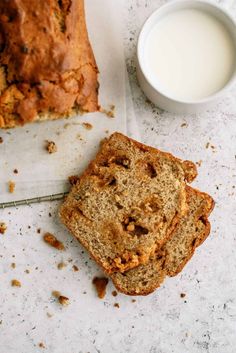 a loaf of bread sitting next to a cup of milk