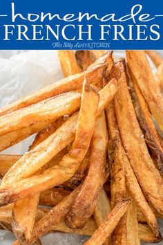 french fries are sitting on wax paper in front of a blue and white checkered table cloth