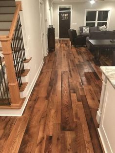 an empty living room with hardwood floors and stairs