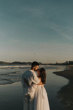 a man and woman kissing on the beach