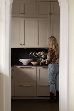 a woman standing in a kitchen preparing food