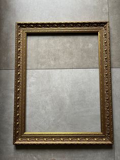 an empty gold frame hanging on the wall