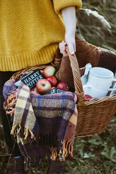 a person holding a basket full of apples