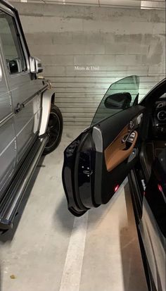 two cars parked in a parking garage next to each other and one has its door open