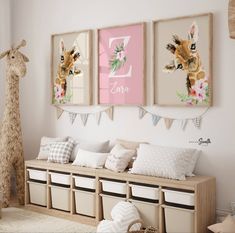 a nursery room with three pictures on the wall and two stuffed animals hanging above it