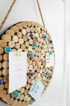 a cork board with wine corks and notes attached to it hanging on the wall