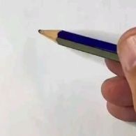 a person holding a pencil in their left hand