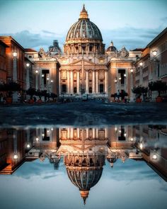 a large building with a dome in the middle of it's reflection on water