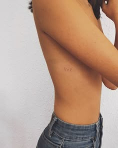 a woman's stomach showing her small breast tattoo