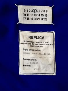 the label for replica clothing is shown in white on blue fabric, with black and white numbers