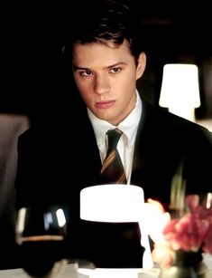 a man in a suit and tie sitting at a table