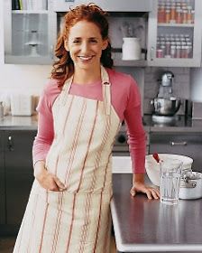 a woman in an apron standing next to a counter