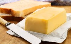 a block of butter next to a knife on a cutting board