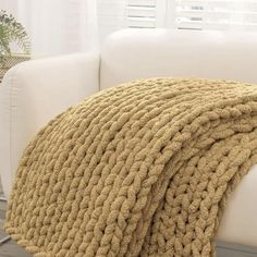 a white couch with a blanket on top of it