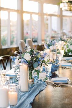 a long table with candles and flowers on it is set up for a formal dinner