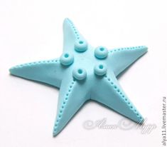 a starfish made out of fondant sitting on a table with buttons attached to it