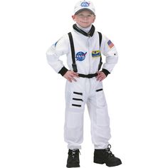 a young boy dressed in an astronaut suit and helmet, standing with his hands on his hips