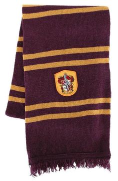 a harry potter scarf with a hogwarts crest on the front and yellow stripes