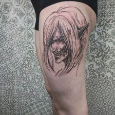 a woman's thigh with a skull and horns tattoo design on it, in front of a wall