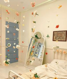 a bedroom decorated in white with flowers and butterflies flying around the room on the ceiling