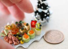 miniature food items displayed on small plate next to coin and tiny toy figurines