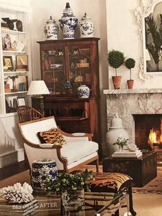 a living room filled with furniture and a fire place under a mirror on the wall