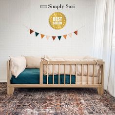 a baby crib in front of a white brick wall with the best seller sign above it