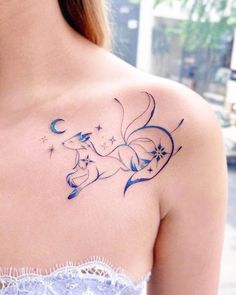 a woman with a tattoo on her shoulder that has an image of a dog and stars