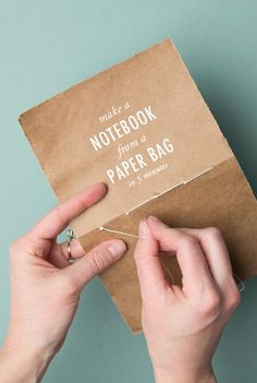 a person holding a brown paper bag with the words make a notebook from a paper bag