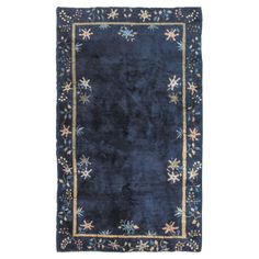 a blue rug with gold trimmings and stars on the border, in front of a white background