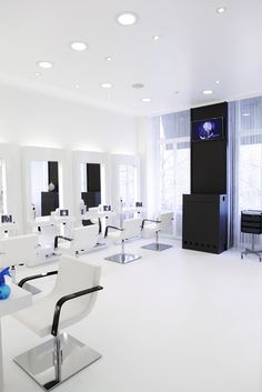 a white room with chairs and mirrors in it