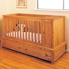 a wooden crib with two puppies in it on a hard wood floor next to a window