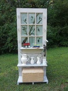 an old window is decorated with vases and other things in front of the hutch