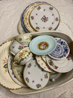 there are many plates and cups on the table together, all in different patterns and colors