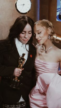 two women are hugging each other while holding their oscars trophies in front of them