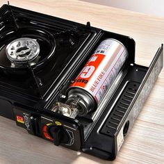 an open black box with a gas can in it on a table next to a lighter