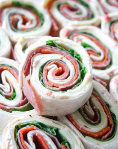 rolls filled with meat, cheese and spinach on top of each other in different colors